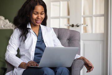 an African American female doctor provides Telemedicine consultations through the transmission of medical information via telecommunications channels