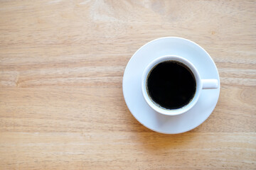 Top view of dark hot coffee cup on wood desk with copy space 