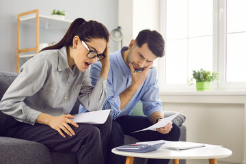 Stressed overwhelmed shocked millennial caucasian couple checking analyzing family bills...
