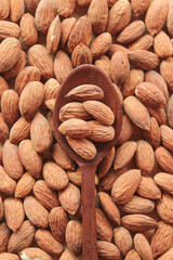 Almond nut in wooden spoon with almond background 