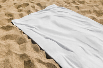 White beach towel on the sand - obrazy, fototapety, plakaty