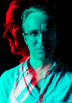 Man with spectacles portrait in double color exposure effect