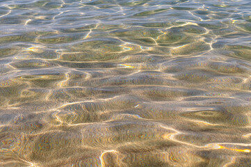 Sun glare on blue water at sea and on a sandy day on a sunny day