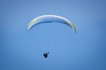 red paraglider on the blue sky in different colours