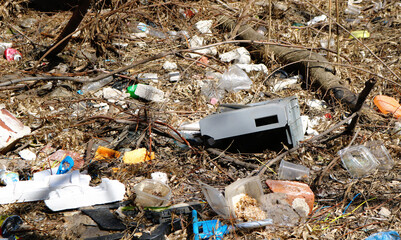 plastic garbage and trash in the ground of a park, to represent polution in the environment