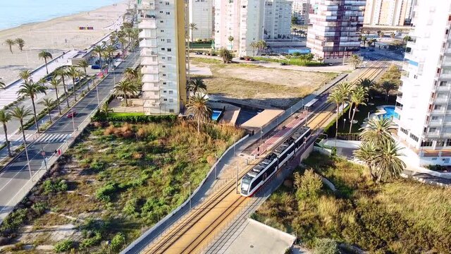 Little modern train transporting people in the mediterranean coast of Spain on a sunny day.