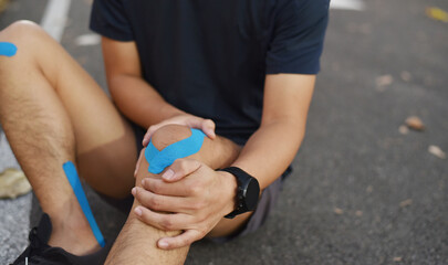 close up of young Asian sports man has pain at muscles and joints during outdoor exercise, over trainning or running and sport injuty concept