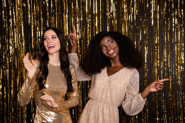 Photo of optimistic brunette ladies dance wear nice dress isolated on bright gold color background