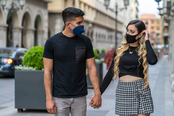 couple in love with a mask due to the Sars-COV2 pandemic. Walking down the street