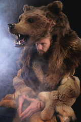 Low key portrait of a bearded war shaman in bearskin with an ancient ax in his hands. High quality...