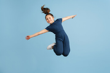 Obraz premium Pretty caucasian girl portrait isolated on blue studio background with copyspace