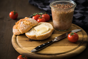 Grobe Leberwurst im Glas aus Vorrat mit Brötchen, Butter und Tomaten als Vesper Brotzeit auf...