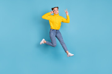 Fototapeta na wymiar Full length photo of cheerful person jump fingers show v-sign near eye isolated on blue color background