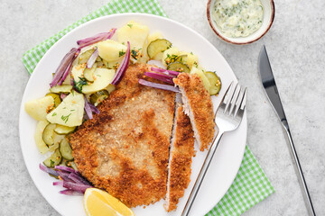 Vienna schnitzel with potatoes and onions.