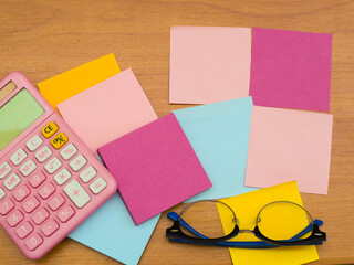 Several notepads and a pink number calculator with glasses.