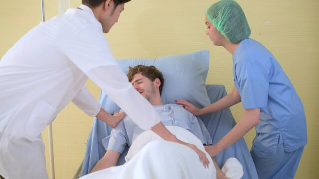 Asian medical staff taking care patient seizuring on bed in hospital.