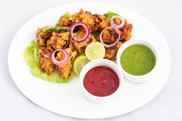 Deep Fried Spicy Indian Street Food With Various Names Like Onion Bhajji Pyaj Pakora Or Pakore Pyaaj Ke Pakode Or Pakoda Kanda Bhaji Pyaaz Bajji Served With Chutney And Sauce Is Tea Time Chaat Snacks