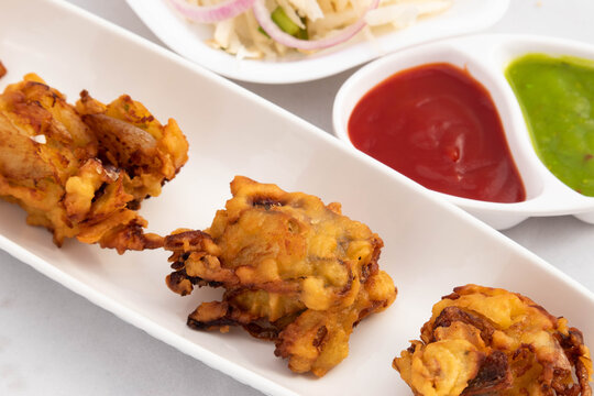 Delicious Indian Street Food With Various Names Like Onion Bhajji Pyaj Pakora Or Pakore Pyaaj Ke Pakode Or Pakoda Kanda Bhaji Pyaaz Bajji Served With Green Chutney And Ketchup Is Tea Time Chaat Snacks