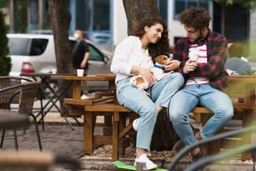 Guy and girl playing with a dog