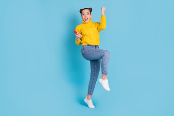 Full length body size view of lovely cheerful girl using gadget dancing having fun isolated over vibrant blue color background