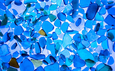 Summer background from sea glass top view. Broken glass from the ocean. Sea pattern. Oceanic mosaic. Natural colors of blue, green, white found on the coast