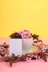 Creative layout  made with flowers and  coffee cup. Spring minimum concept. Pastel pink and yellow background