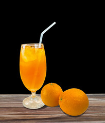 Fresh oranges fruit and a glass of orange juice on black background,