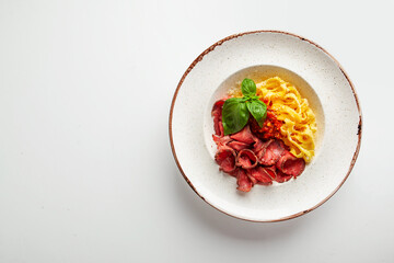 fresh pasta with cheese and meat sauce on a white plate in the studio