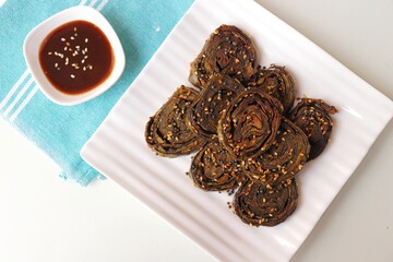 Alu Vadi, Patra, paatra, colocasia leaves roll, Patrode is a popular Indian healthy steamed snack. Garnished with sesame and mustard seeds. served with tamarind chutney. copy space.