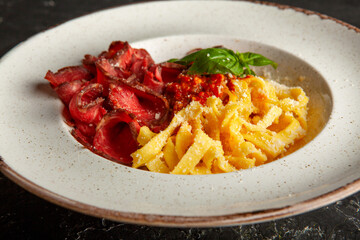 fresh pasta with cheese and meat sauce on a white plate in the studio
