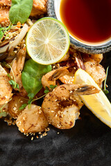 Teppanyaki Style Seafood - Grilled Mixed Seafood with Soy Sauce and Vegetables. Japanese Teppanyaki Salmon Steak, Shrimp, Scallop and Fish Fillet garnished with lemon and green salad.