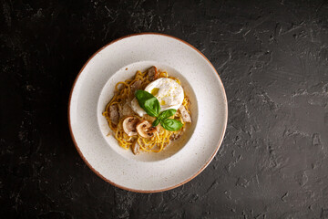 fresh pasta with cheese and mushroom sauce on a white plate in the studio