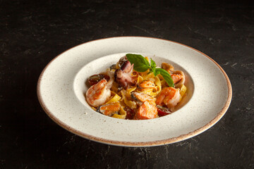 fresh pasta with seafood on a white plate in the studio