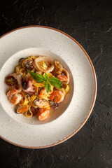 fresh pasta with seafood on a white plate in the studio