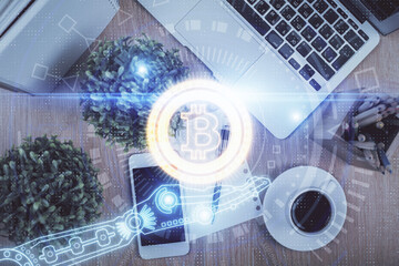 Double exposure of blockchain theme hologram over table with phone. Top view. Crypto technology...
