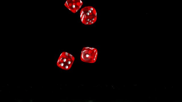 Dices falling on black table in super slow motion