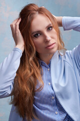 young beautiful Caucasian woman, in a blue suit, on a blue background.