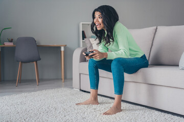 Full body profile side photo of young excited black girl happy smile play video game joystick console sit couch home