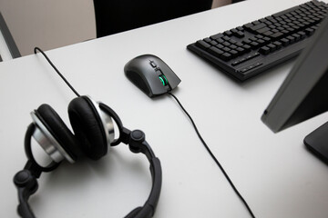 Headphones, keyboard, mouse and monitor on the desk