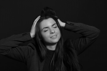 Black and white portrait of a young brunette woman in a studio on a black background