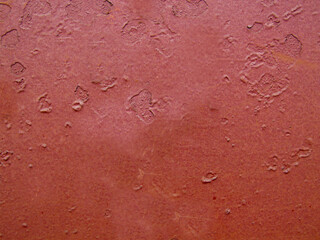 Damaged old maroon wall close-up with detailed texture