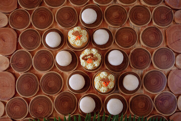 white delicate lowly macaroons on a wooden background. The pastel tone of the cream inside the French cookies
