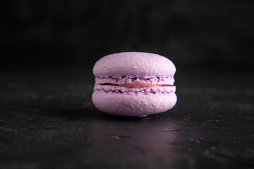 colored fresh macarons in studio on black background