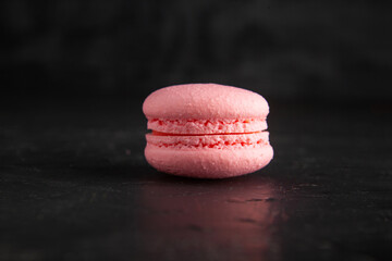 colored fresh macarons in studio on black background