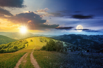 day and night time change concept above road through meadow in mountains. beautiful rural landscape...