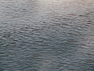 Small waves of sea water close up dark blue color close up
