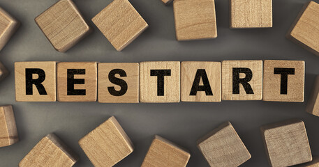 The word Restart on small wooden blocks at the desk. Top view