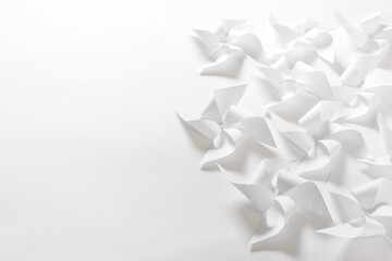 Handmade origami paper composition with white flowers figures on white paper. Photo with copy blank space.