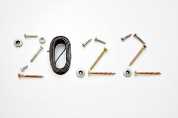 New Year 2022 numbers arranged with mettalic screws and wire on white background.