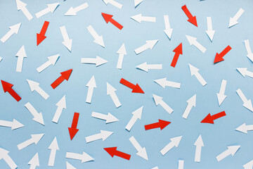 Concept of chaos randomly arranged many white and red paper arrows on blue background. - obrazy, fototapety, plakaty